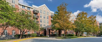 Exterior view of assisted living facility with trees and landscaping