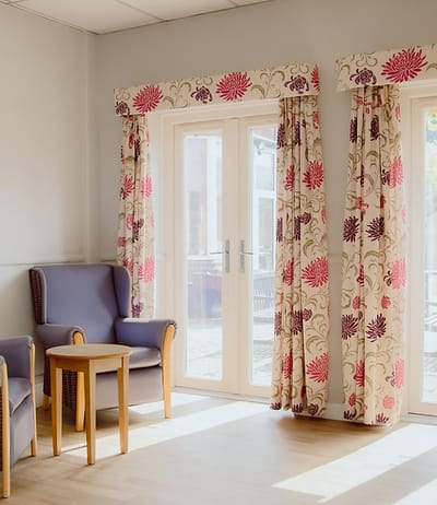 A cozy interior space with floral curtains.