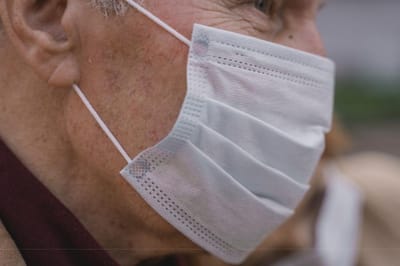 Close-up of an elderly person wearing a mask.