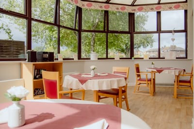 Bright dining area with tables and chairs.
