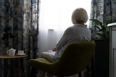 A senior woman sitting by a window