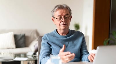 Senior man engaged in conversation on a laptop