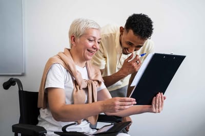 Care staff engaging with a resident in a cheerful setting.