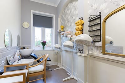 Hair salon area with styling equipment and towels