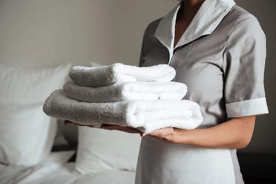 Care staff holding fresh towels in a room