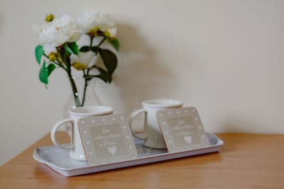 Decorative coffee setup with flowers and coasters.