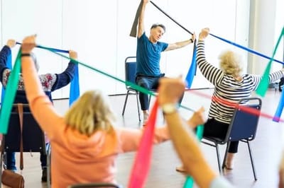 Seniors participating in a seated exercise class