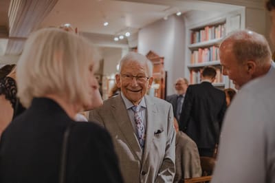 Elderly gentleman smiling in a social gathering