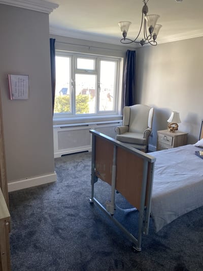 Private resident room with bed and armchair