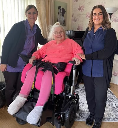 Staff members with a resident in a wheelchair