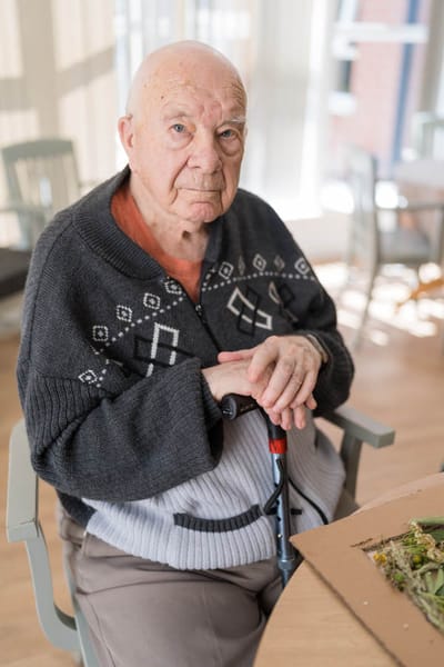 Elderly man sitting in a social area.