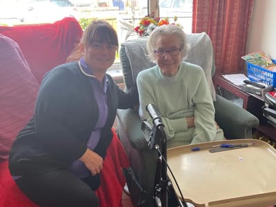 Senior resident and caregiver smiling together