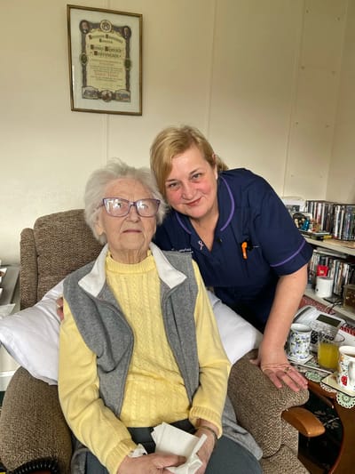 Elderly resident with caregiver in a cozy interior