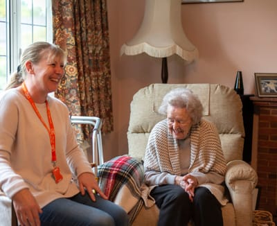 Caregiver and elderly resident sharing a joyful moment.