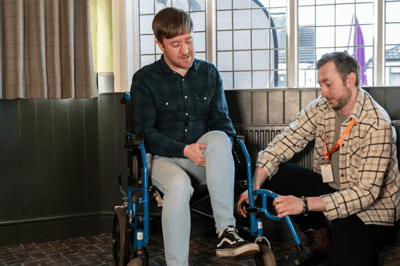 Staff assisting a resident in a wheelchair