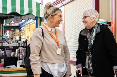 Staff member engaging with a resident at an event.