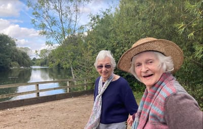 Two elderly women enjoying a scenic outdoor walk.