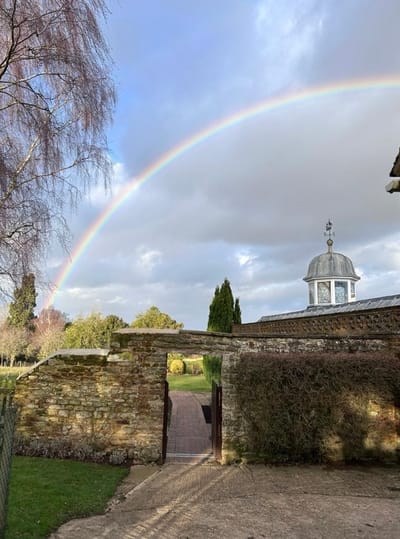 Rainbow arching over garden entrance