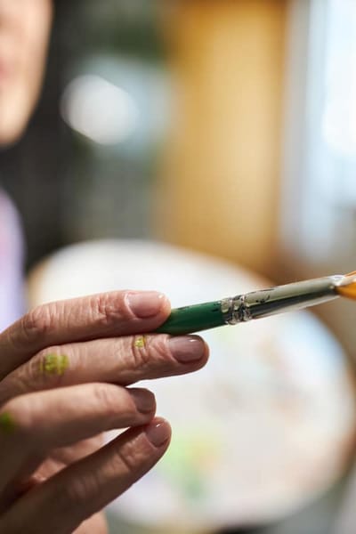 Close-up of a hand holding a paintbrush