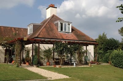 Exterior view of Woodside House with garden and seating