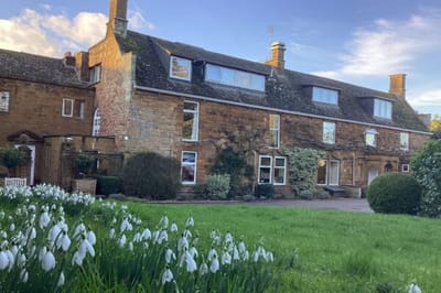 Historic building with landscaped garden and snowdrops.