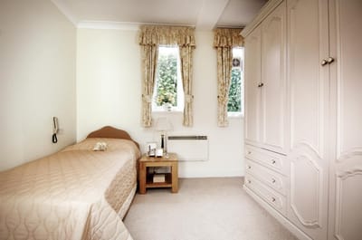Cozy resident room with a bed and wardrobe