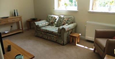 Cozy common area with floral sofa and natural light.