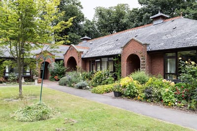 Exterior view of Woodside House facility with gardens