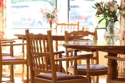 Wooden dining tables with flowers in a vase