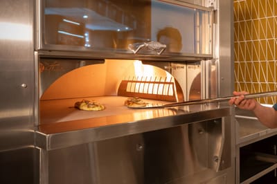 Freshly baked pizzas in an oven.