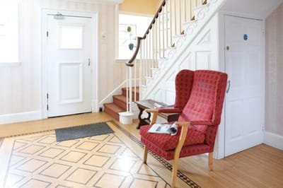 Cozy interior with a red chair and stairway.