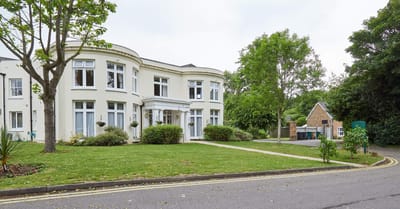 Exterior view of Woodside House surrounded by greenery.