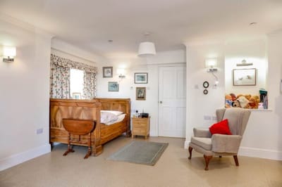 Cozy resident room with wooden bed and chair.