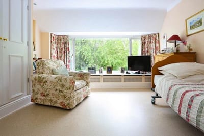 Cozy resident room with a view and comfortable chair.