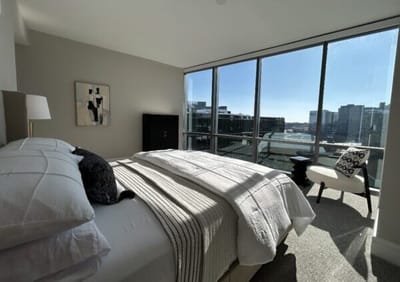Comfortable bedroom with large windows and city view.