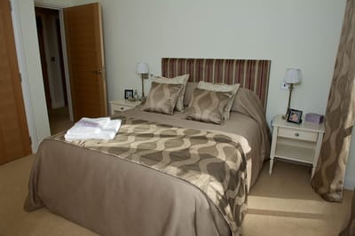Cozy bedroom with a neatly made bed and towels.