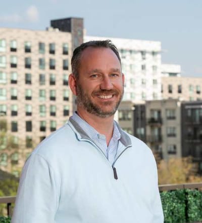 Smiling staff member with building backdrop