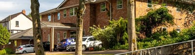 Exterior view of Dean Lodge with vehicles
