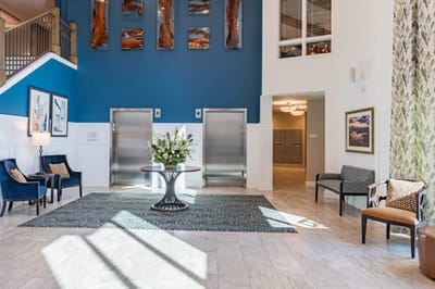 Bright interior lobby with seating and floral arrangement.
