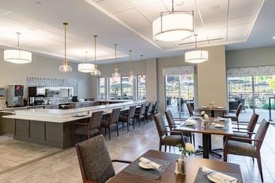 Dining area with tables and chairs, bright lighting.
