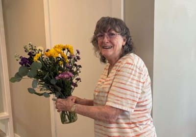 Resident holding a bouquet of flowers in the facility