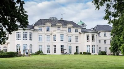 Exterior view of Woodside House surrounded by green space.