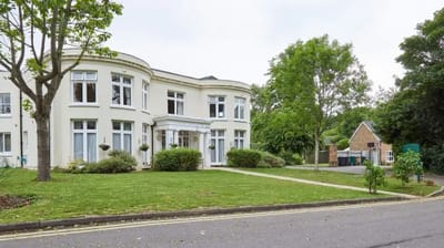 Exterior view of Woodside House with landscaped garden.