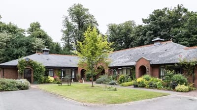 Exterior view of Woodside House with gardens