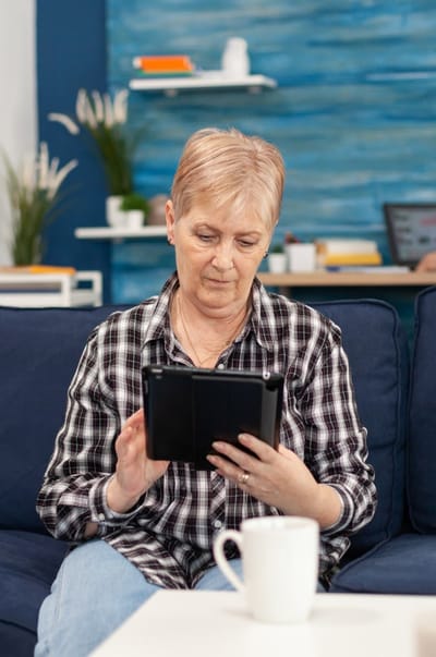 Senior woman using a tablet in a cozy living space.