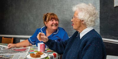 Care staff and resident sharing a meal