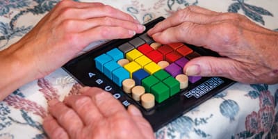 Two hands engaging with a colorful puzzle game.