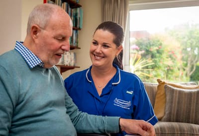 Staff member interacting with a resident in a cozy space.