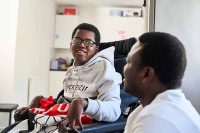 Two people smiling and interacting indoors.