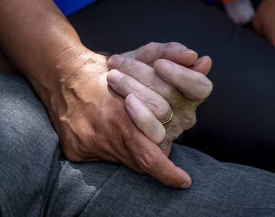 Two hands holding, symbolizing care and connection.